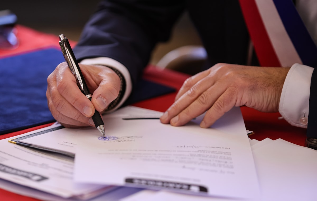 Person signerer et dokument med penn – forliksklagen er et skriftlig dokument